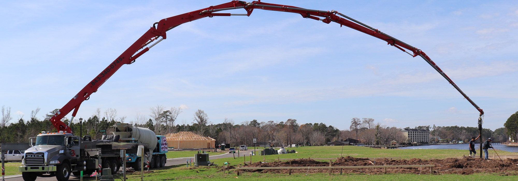 Boom pump services placing concrete over a house roofline in Oklahoma